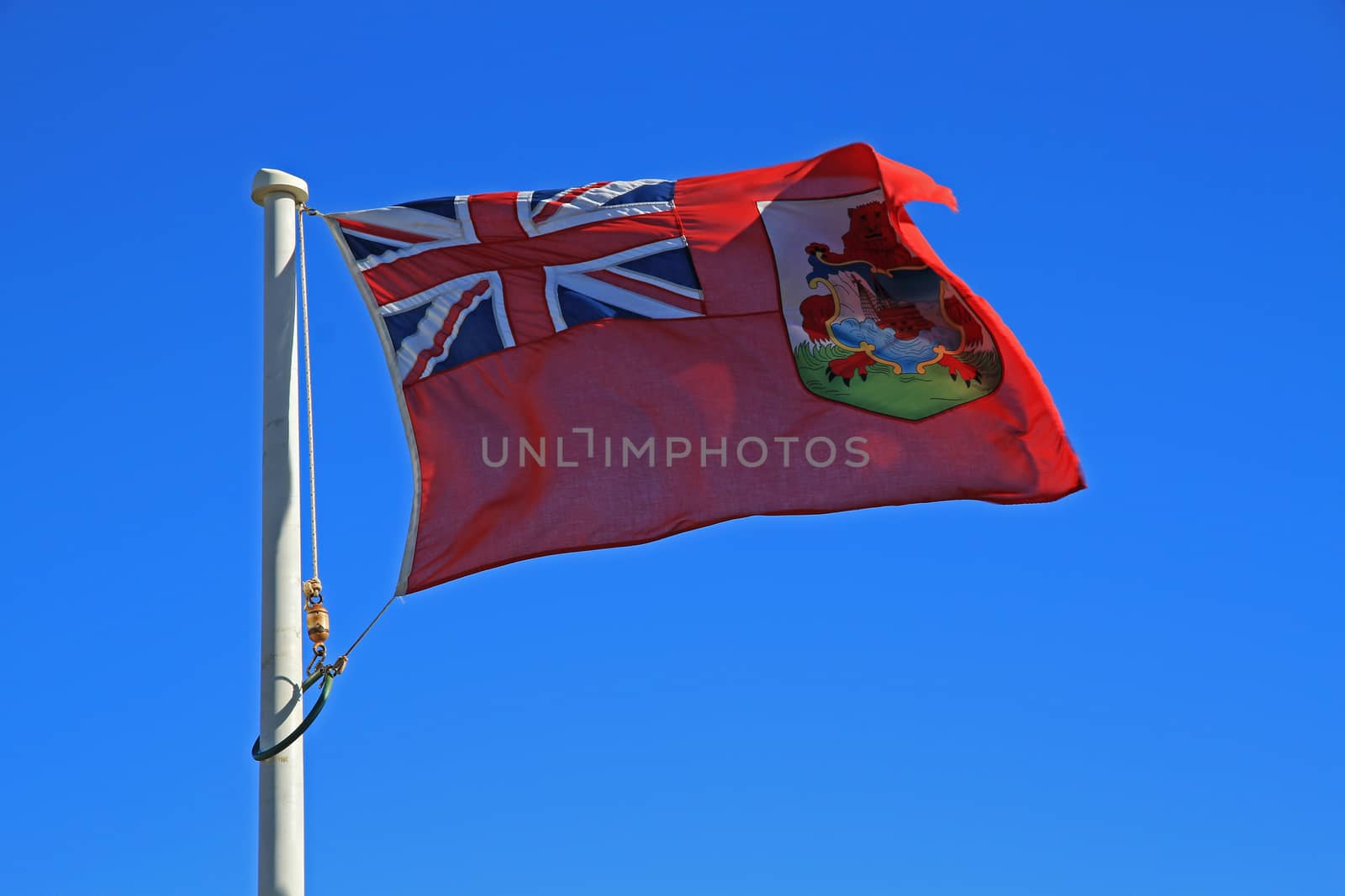 The Bermuda flag, flying against a deep blue sky