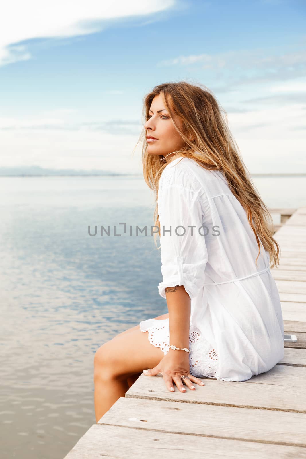 Portrait of Young woman in white clothes on a pier