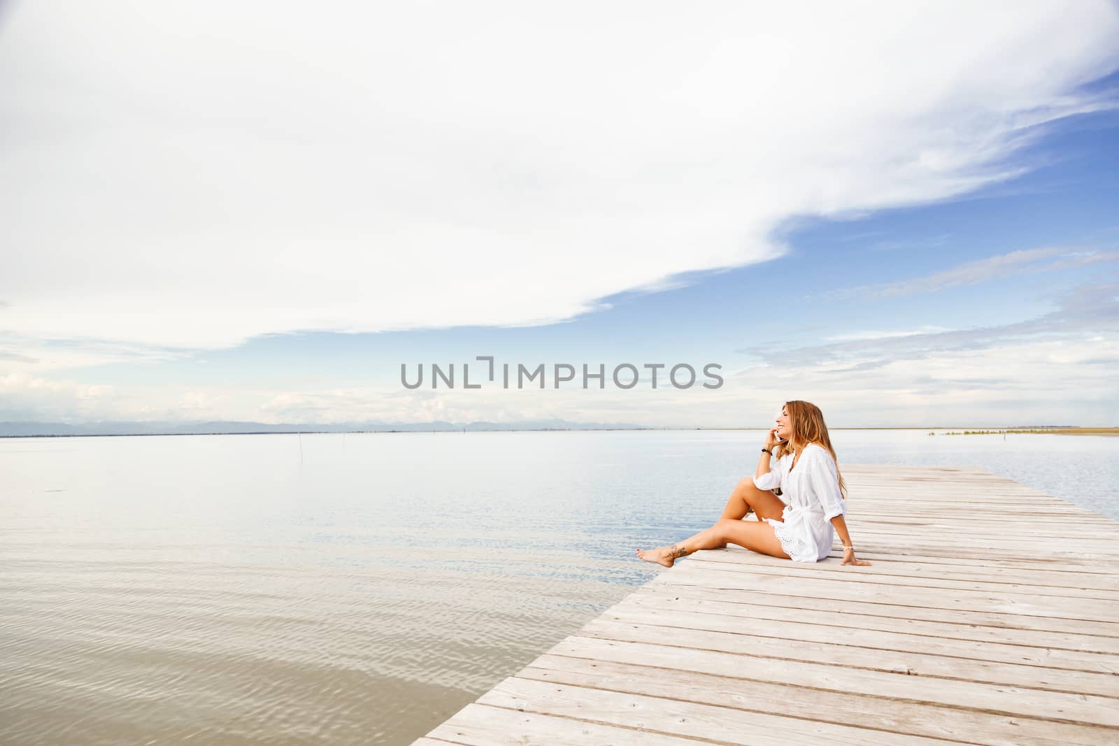 Portrait of smiling Young woman talking on the phone on a pier