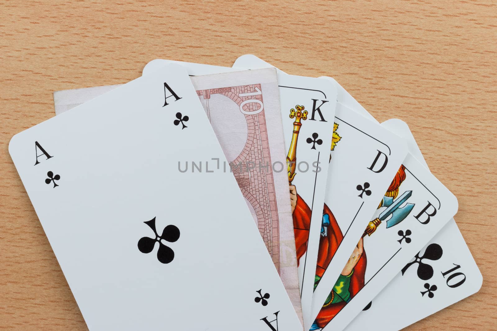 Deck of poker cards showing a Royal Flush with a Euro note