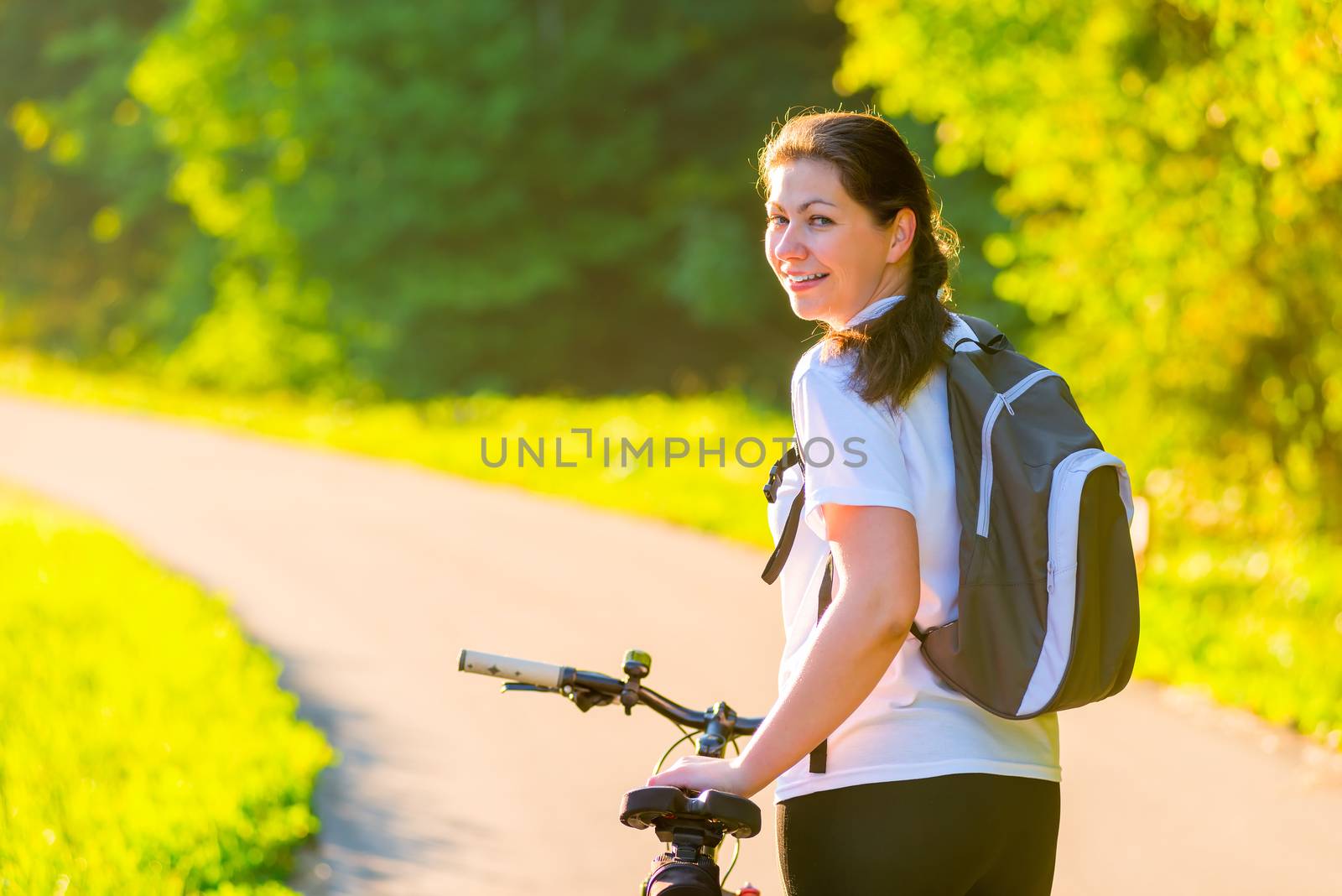 Brunette rides a bicycle on a sunny morning by kosmsos111