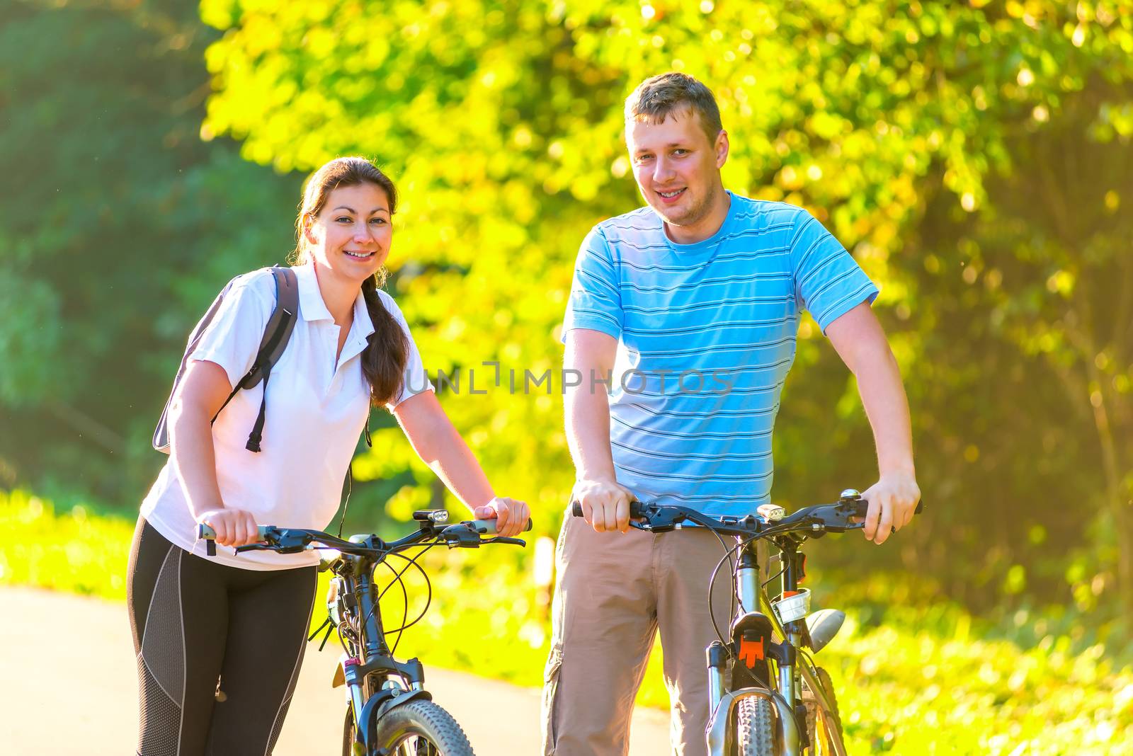 young couple on the weekend to ride a bike in the park