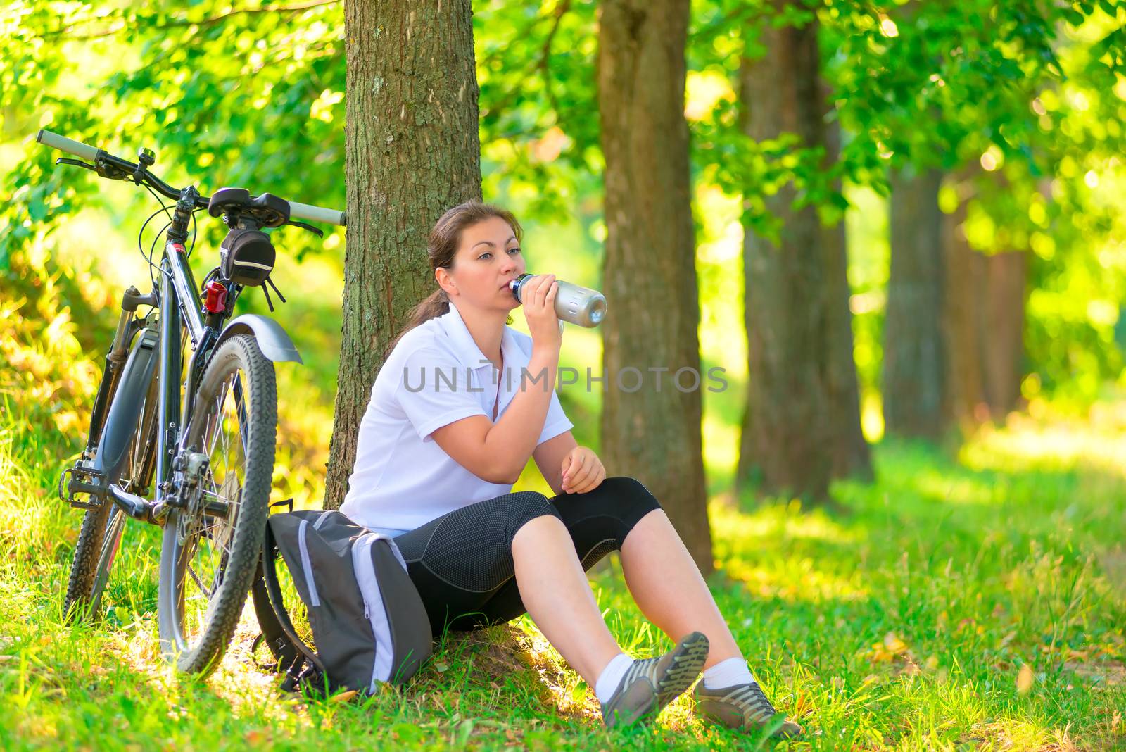 young woman with bottle of water resting near a tree by kosmsos111