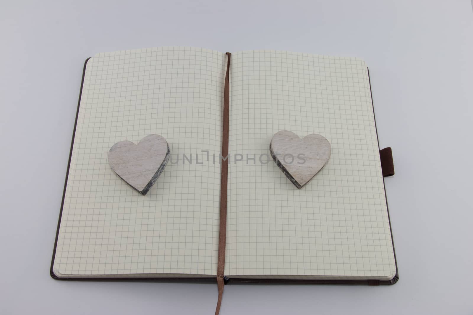 Opened notebook with wooden heart on each side