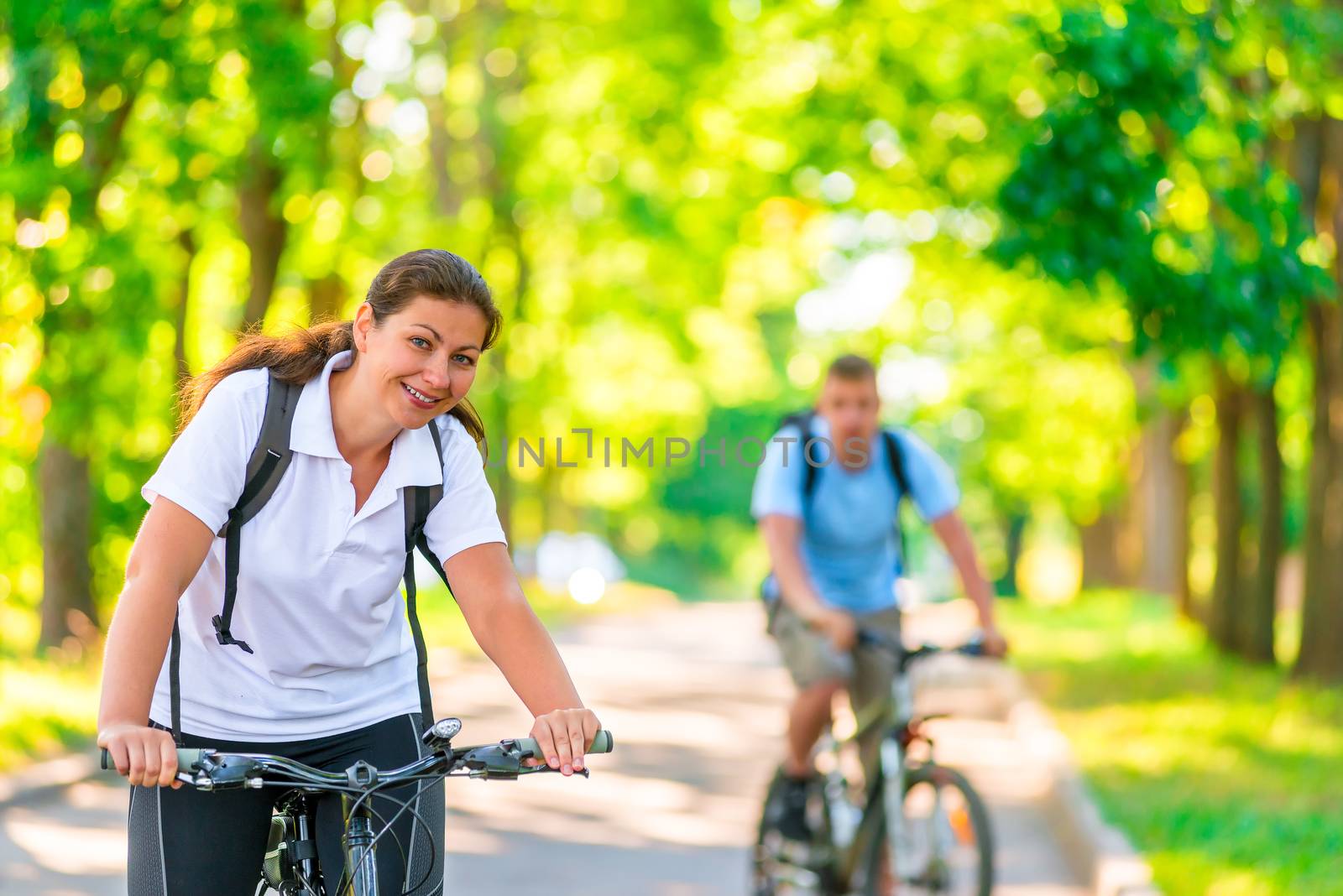 a couple of cyclists riding in the park