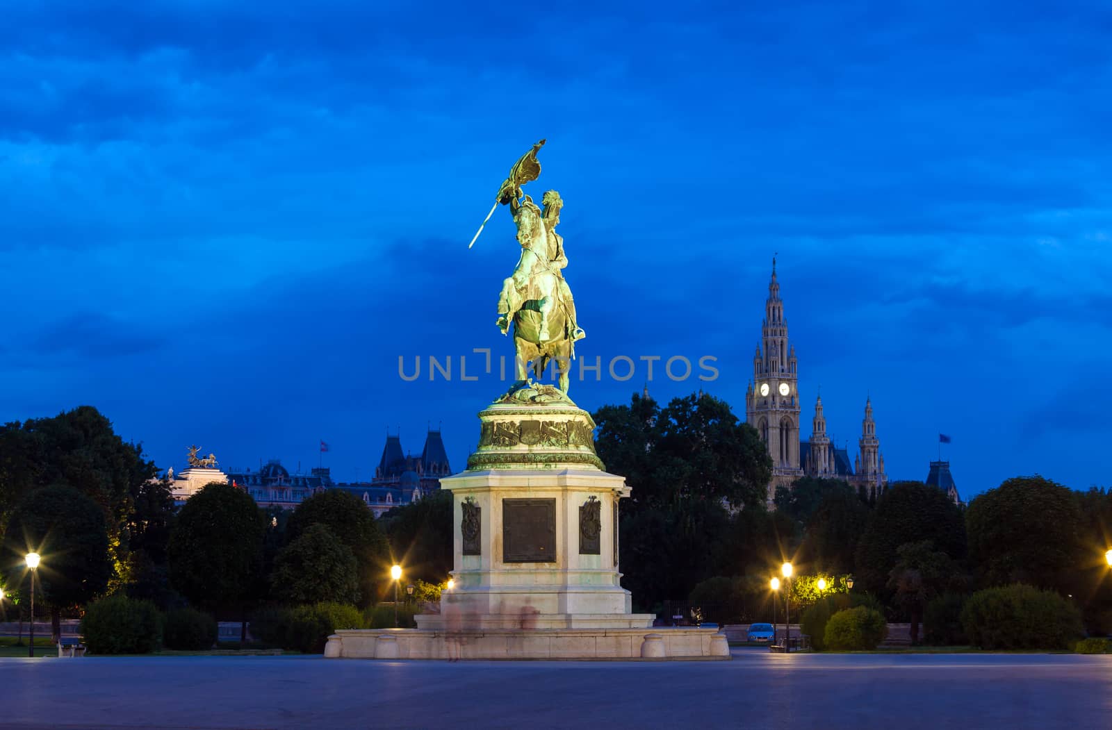 VIENNA, AUSTRIA - AUGUST 4, 2013: Monument dedicated to Archduke Charles of Austria (Erzherzog Karl) ridding a horse and the city hall (Rathause) in Vienna, Austria.