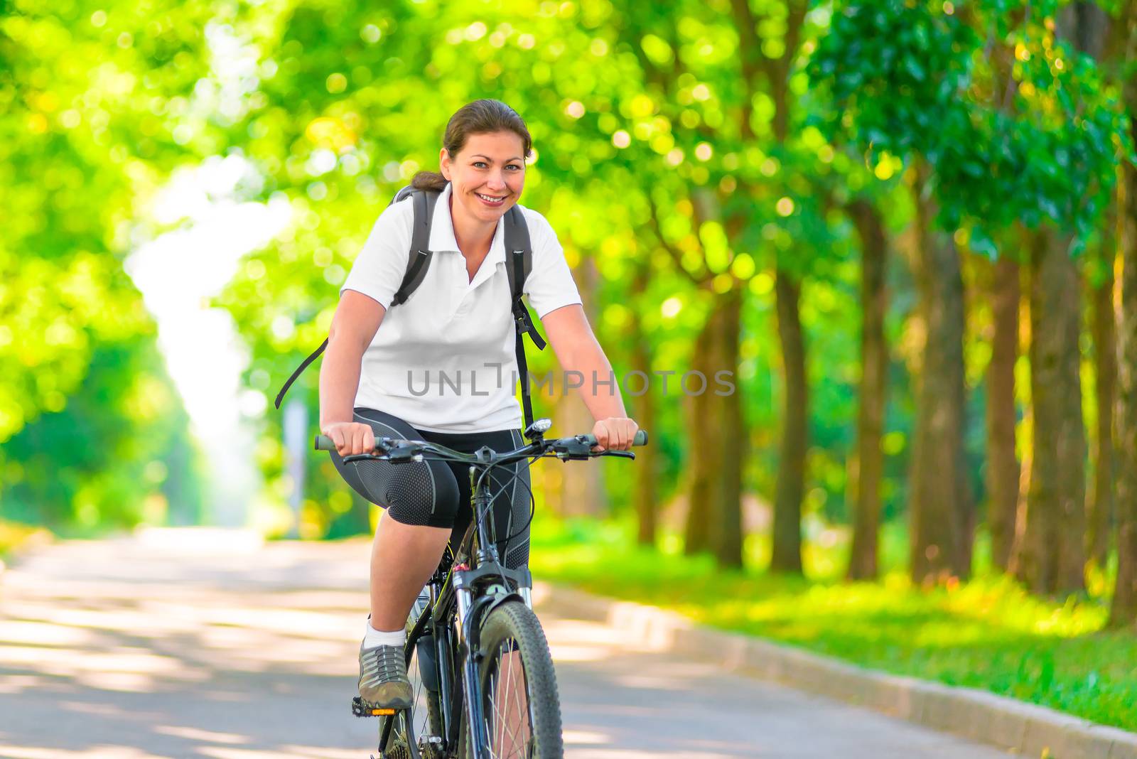 Joyful girl on a bicycle with a backpack by kosmsos111