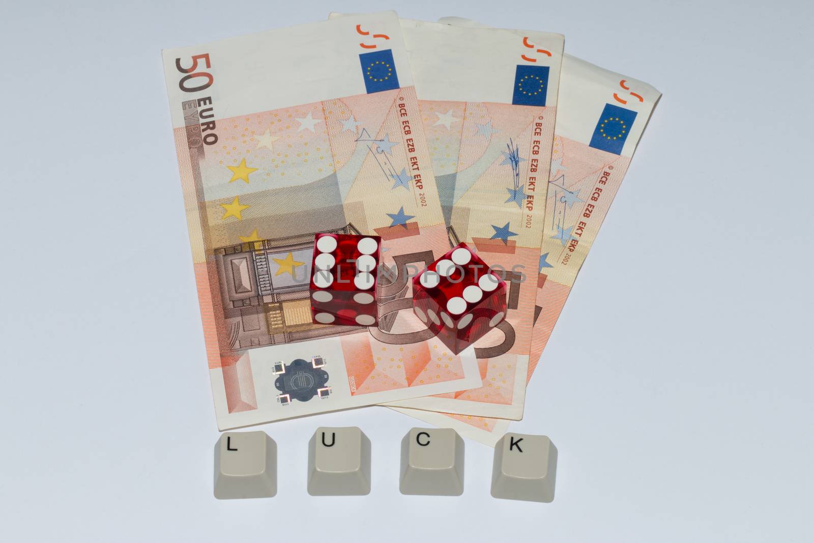 Two dices showing "6", three Euro notes and writing "LUCK", formed by the keys of a keyboard