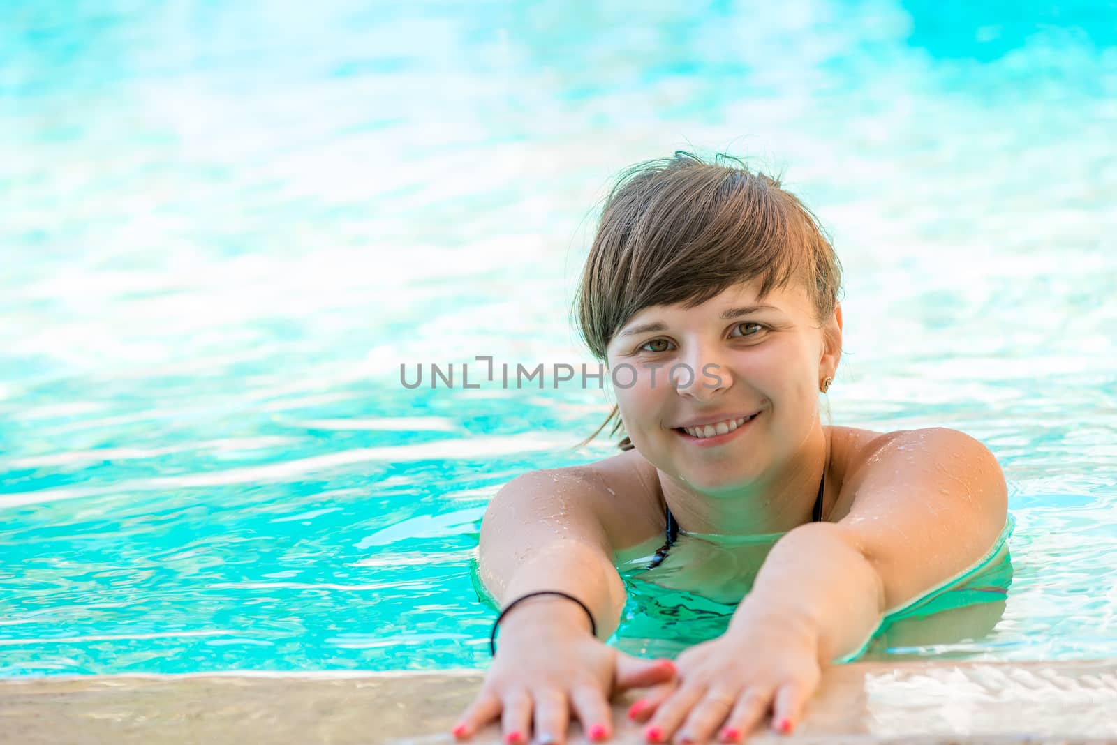 cheerful young girl spends time in the pool