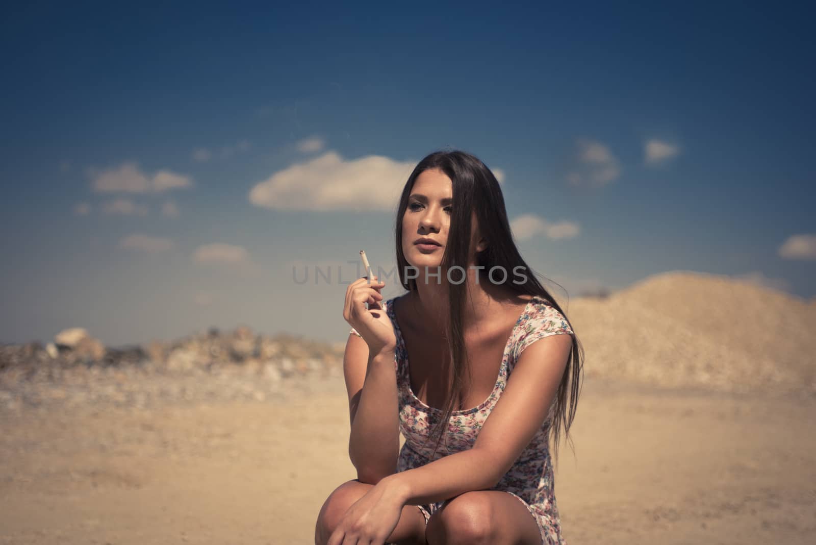 Lady in summer dress hitchhiking on a sunny day