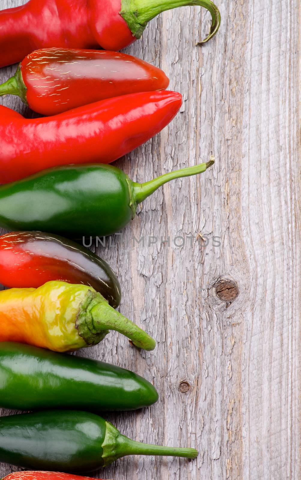 Frame of Red and Green Habanero and Jalapeño Chili Peppers isolated on Rustic Wooden background