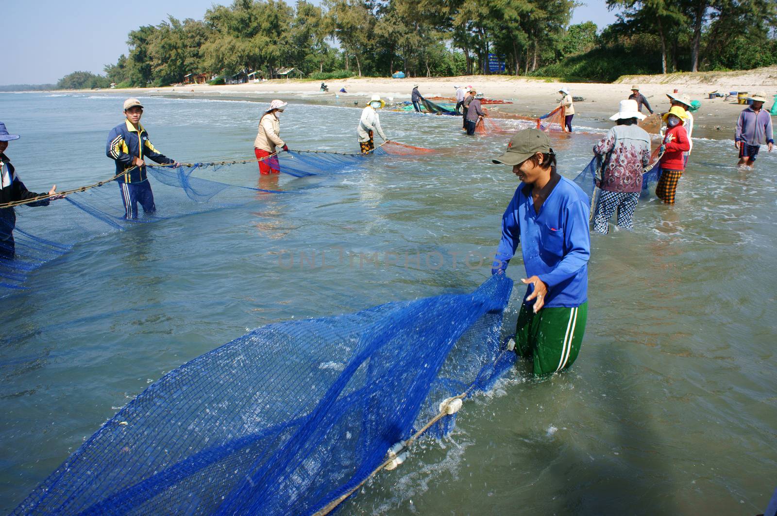 Team work of fisherman on beach by xuanhuongho