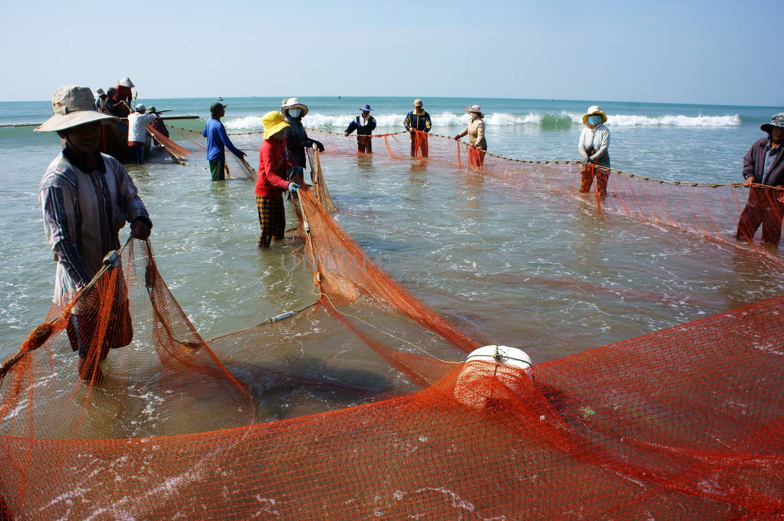 Team work of fisherman on beach by xuanhuongho