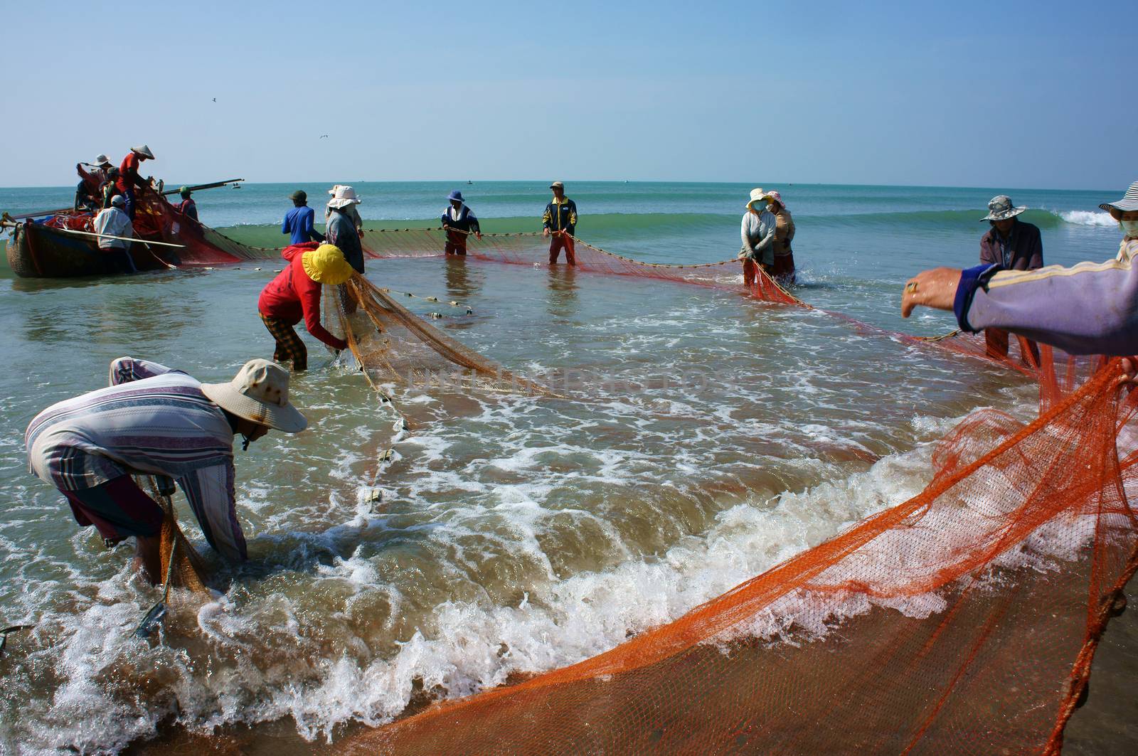 Team work of fisherman on beach by xuanhuongho