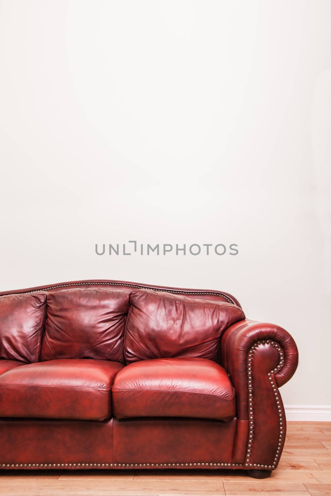 Luxurious Red Leather Couch in front of a blank wall to ad your text, logo, images, etc.