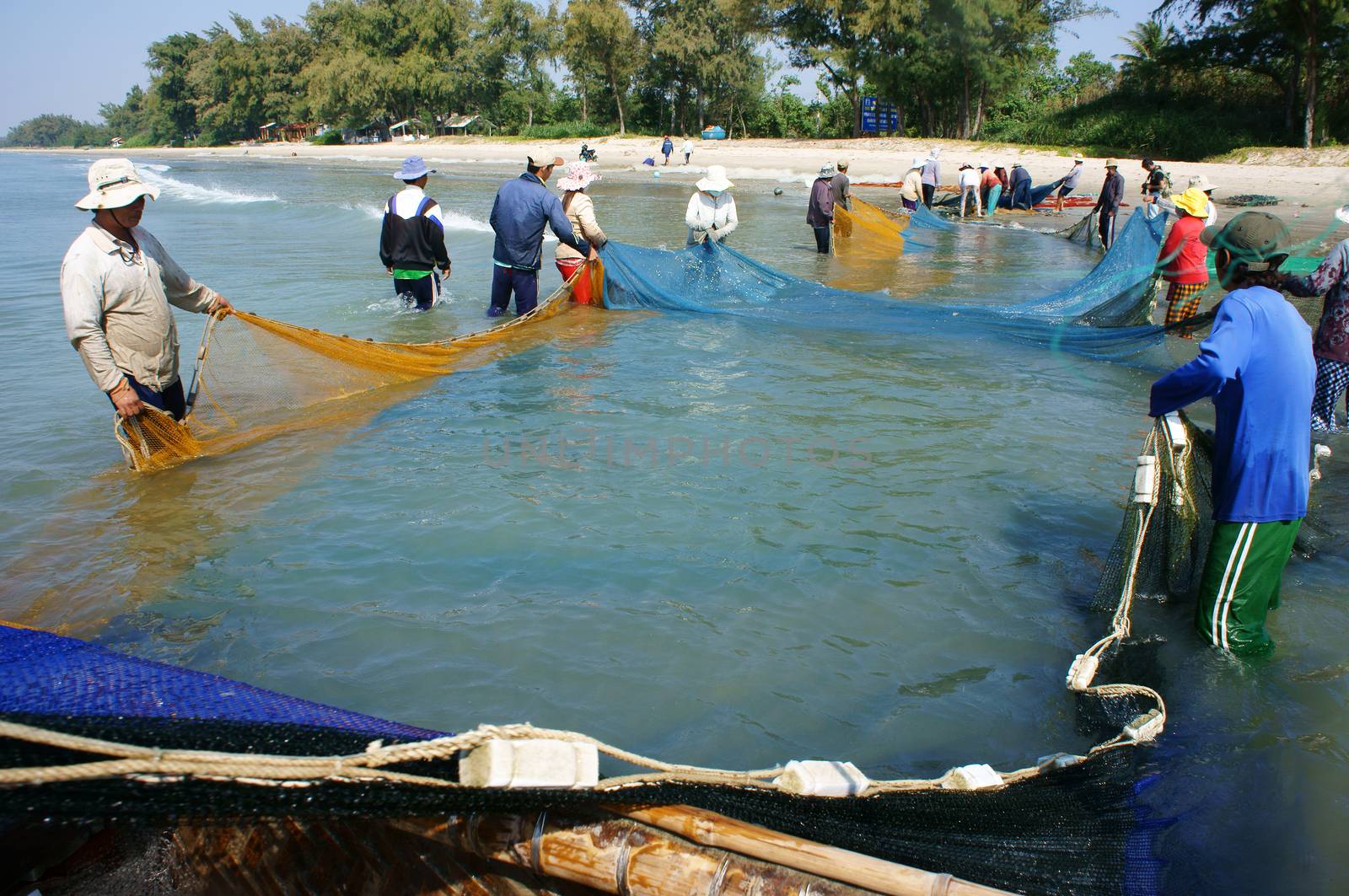 Team work of fisherman on beach by xuanhuongho