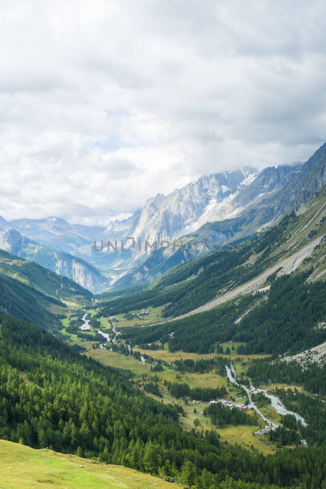 Early morning in Val Ferret valley in Italy, with overcast sky and rocky mountain range
