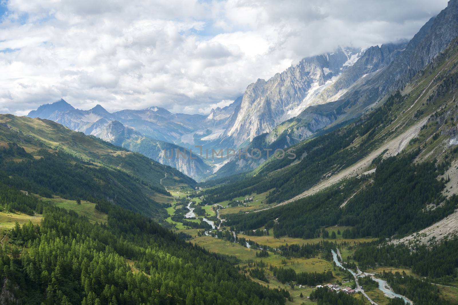 Early morning in Val Ferret valley in Italy, with overcast sky and rocky mountain range