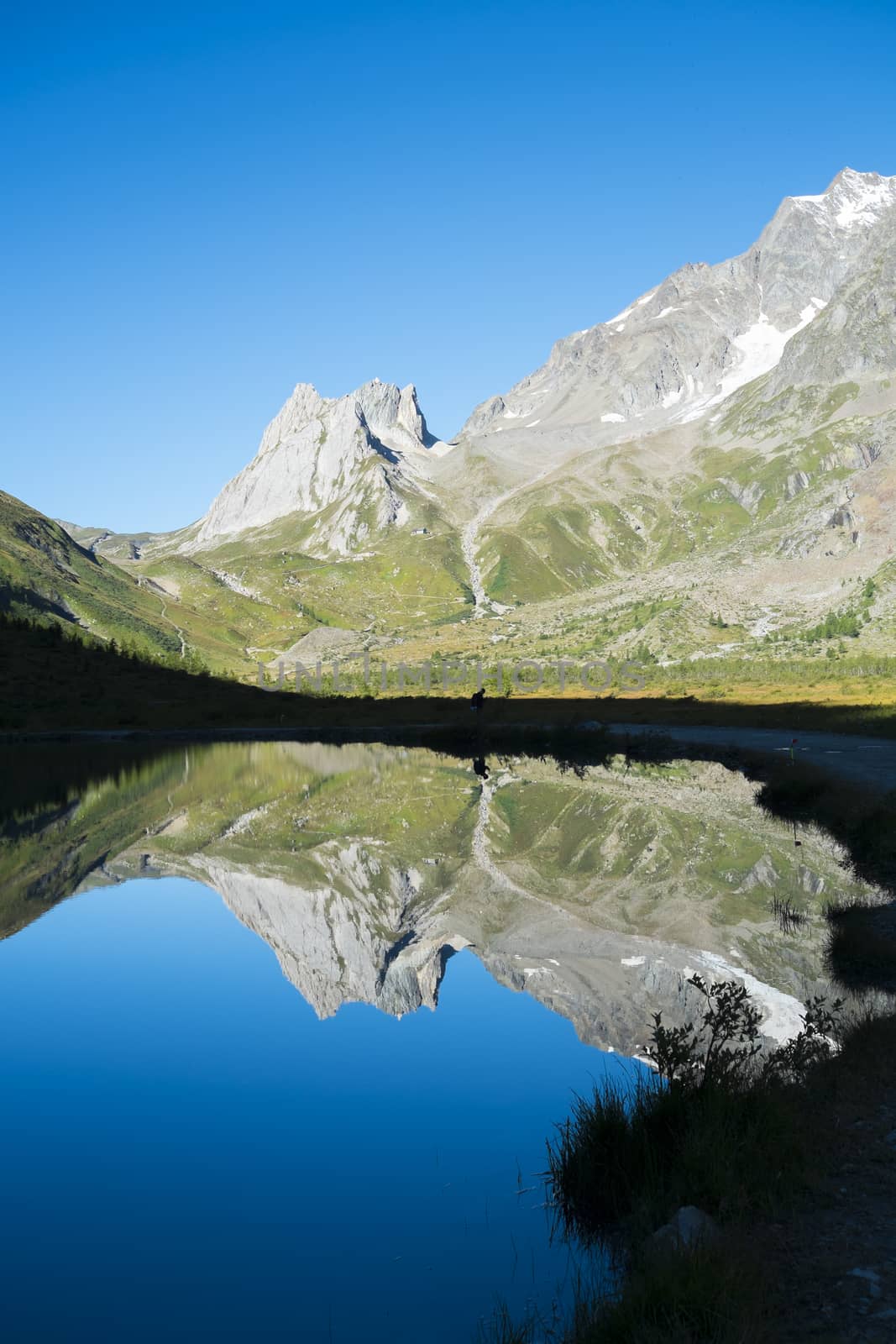 Limestone Pyramids reflected on Combal Lake waters in Val Veny, Italy