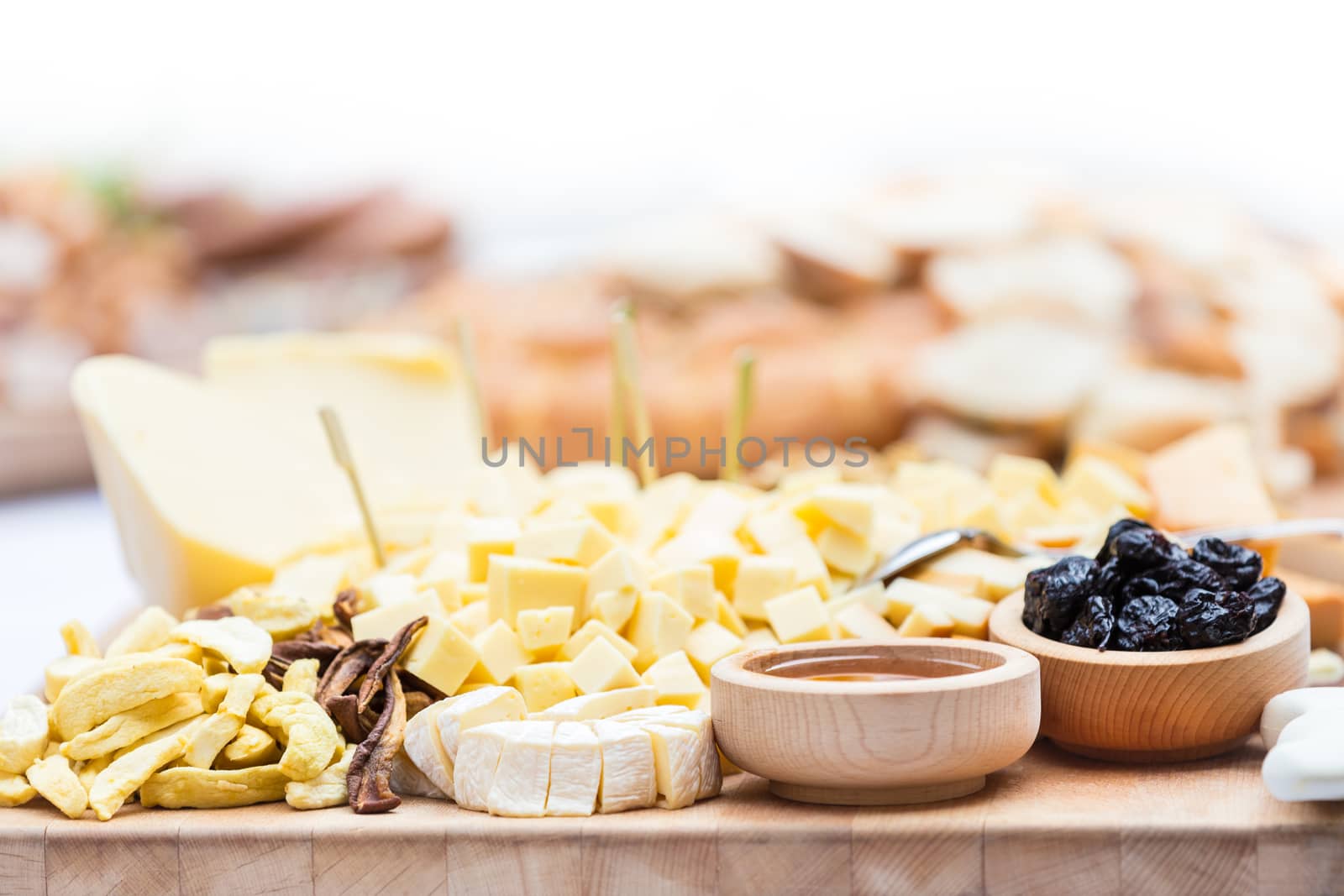 Cheese Plate with Dried Fruit and Honey. Rustic decoration on a wooden plate.