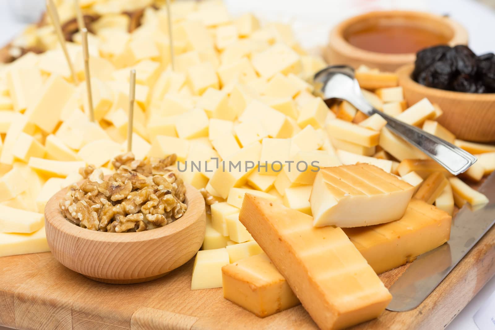 Cheese Plate with Dried Fruit, Nuts and Honey. Rustic decoration on a wooden plate.