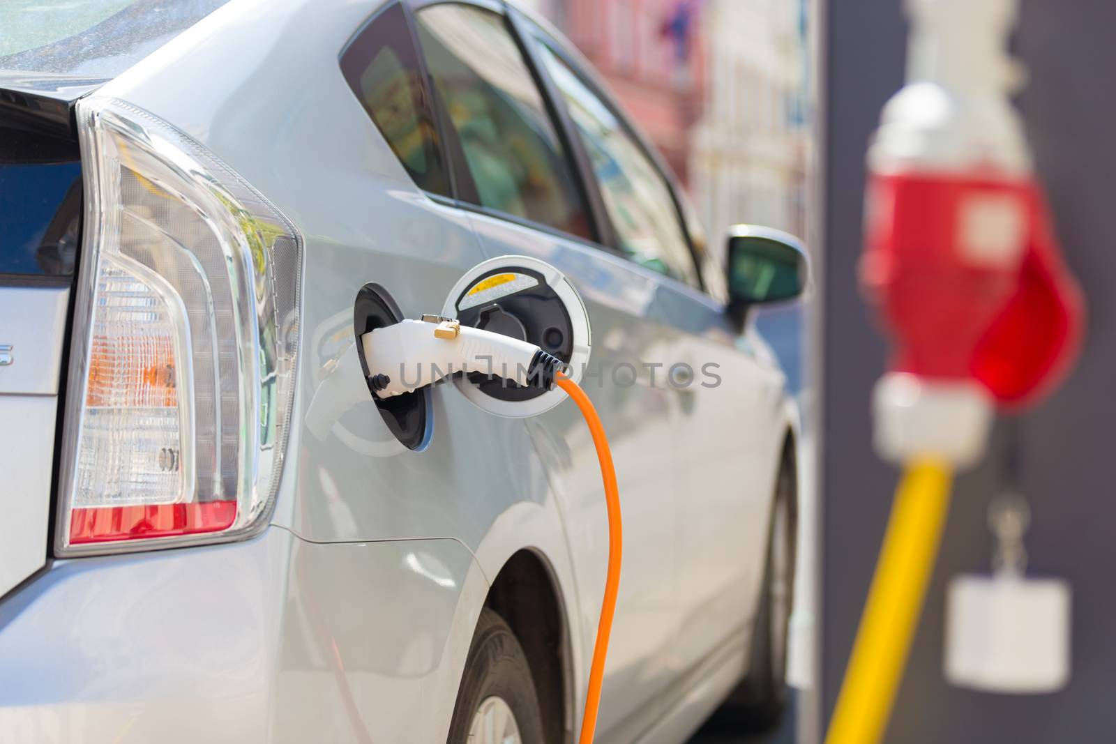 Power supply for electric car charging.  Electric car charging station. Close up of the power supply plugged into an electric car being charged.