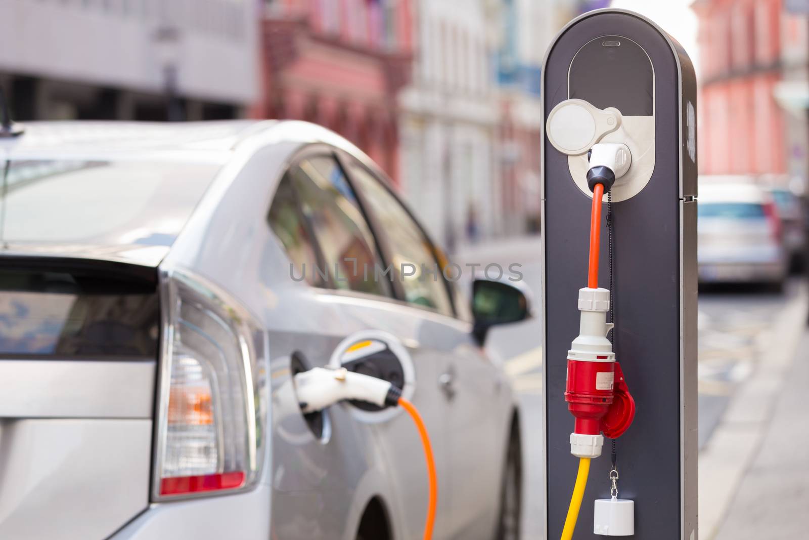 Power supply for electric car charging.  Electric car charging station. Close up of the power supply plugged into an electric car being charged.
