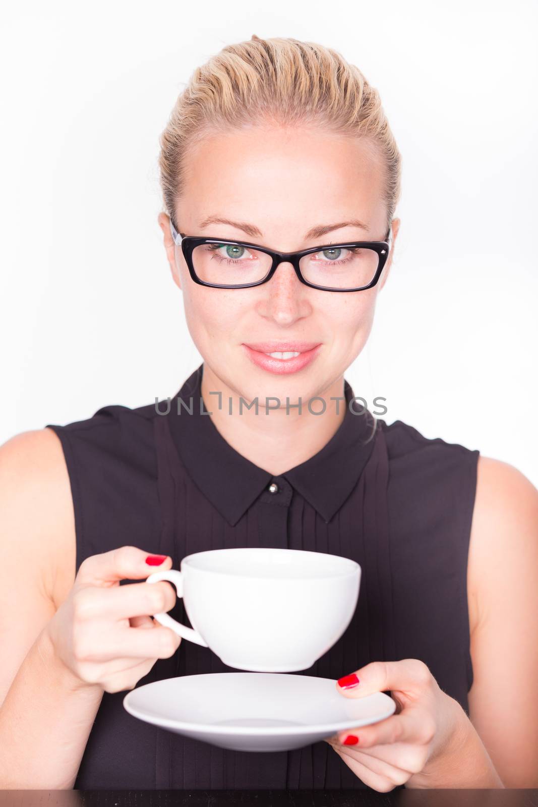 Business woman wearing black glasses holding white cup of coffee in her hands. Coffee break.