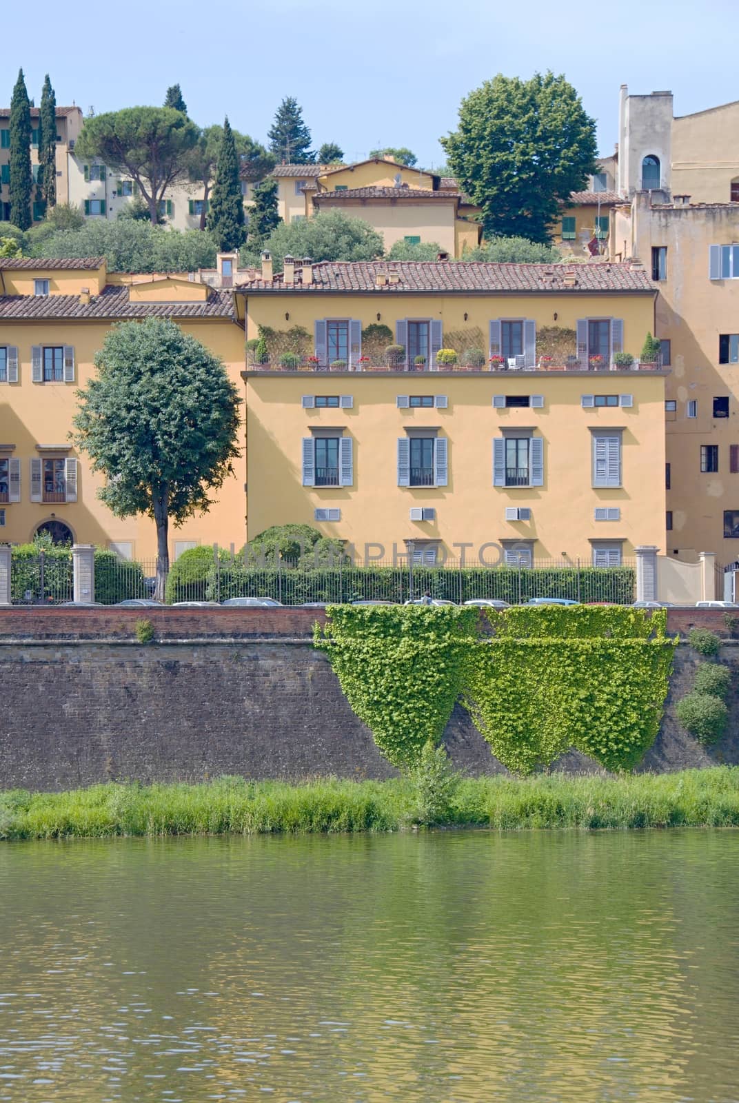 Photo shows a general view onto the city river bank with its houses.