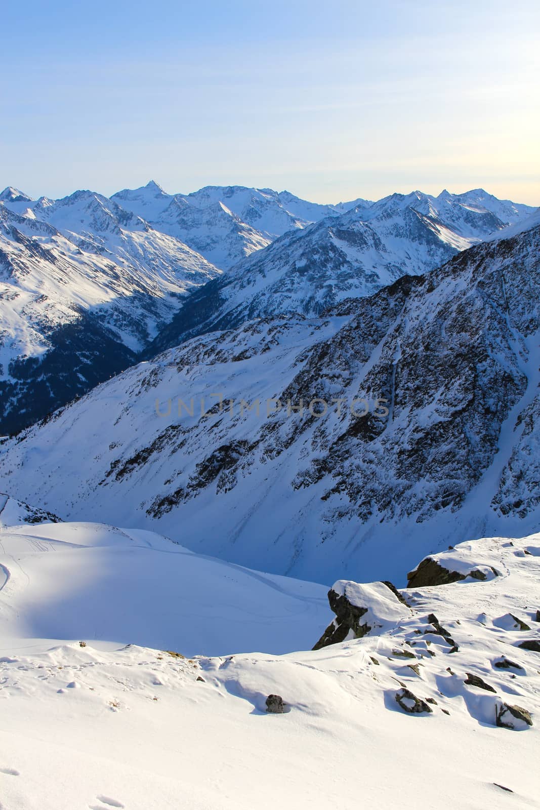 Tops of winter alp mountains at sunny day