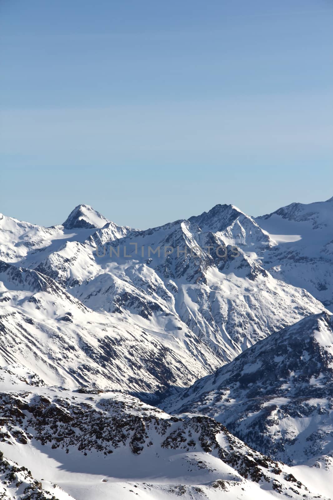 Tops of winter alp mountains at sunny day