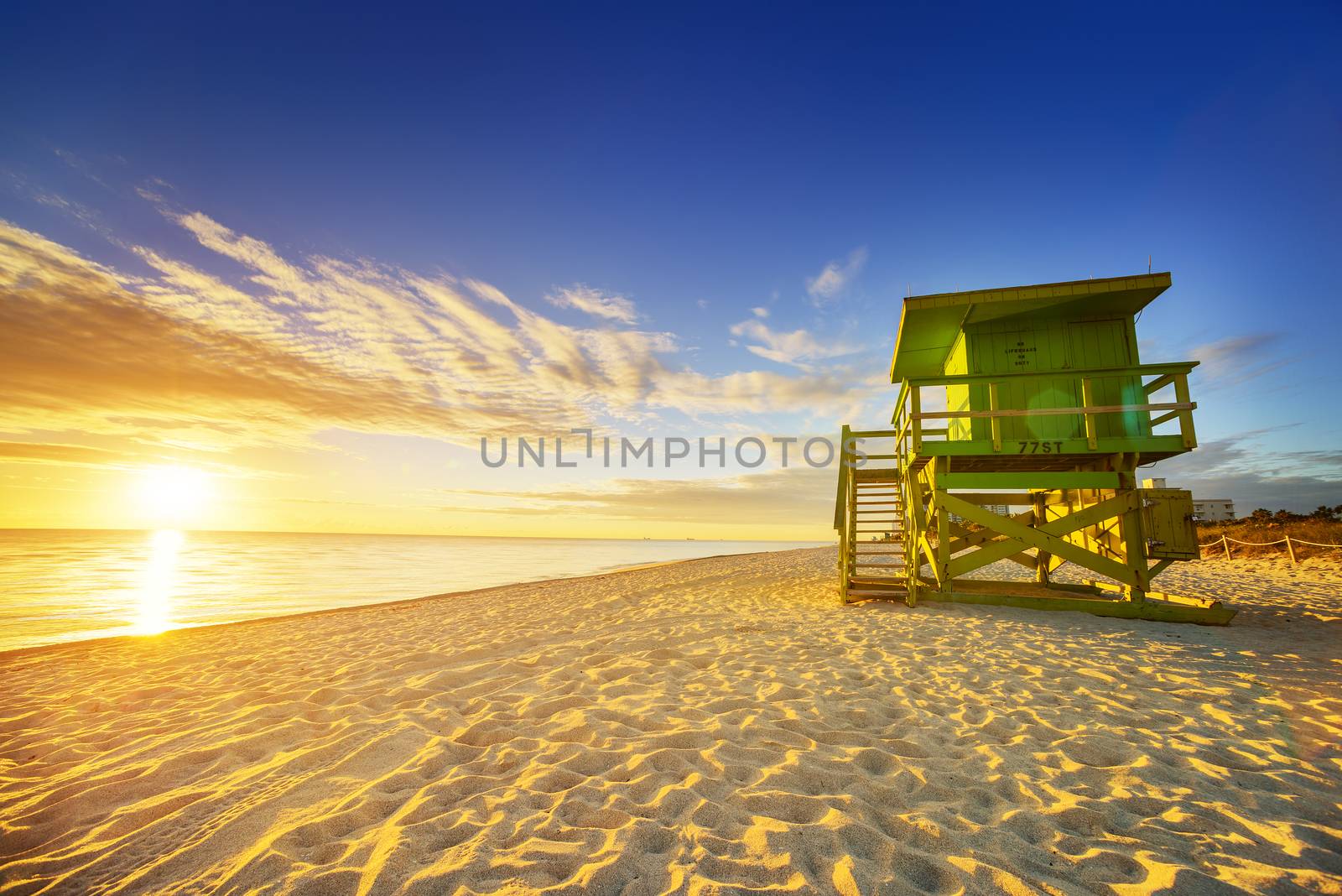 Miami South Beach sunrise with lifeguard tower and coastline with colorful cloud and blue sky. 