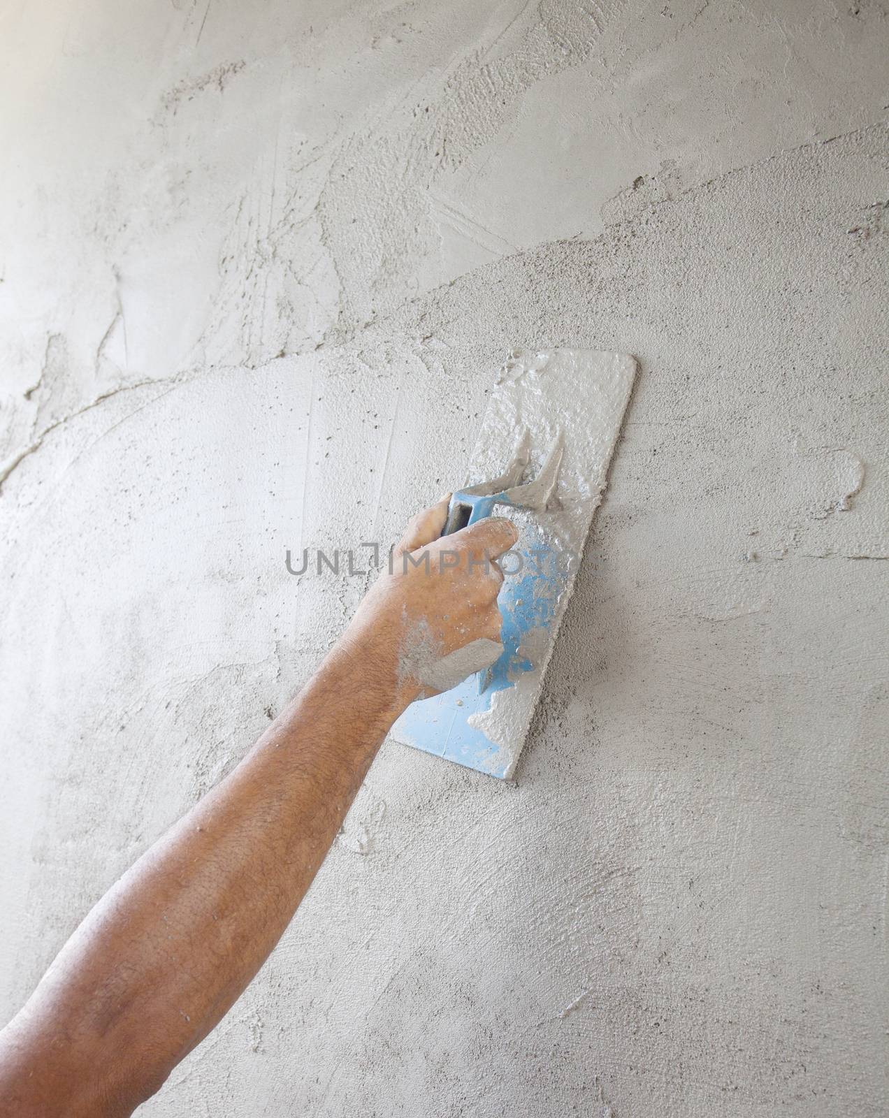 worker hand working to built cement wall of home construction by khunaspix