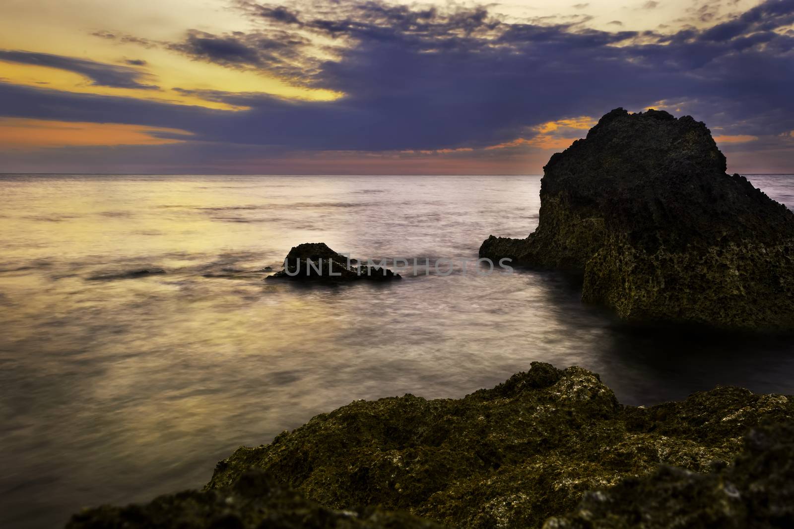 Fiery sunset, rock, and beach, Philippines