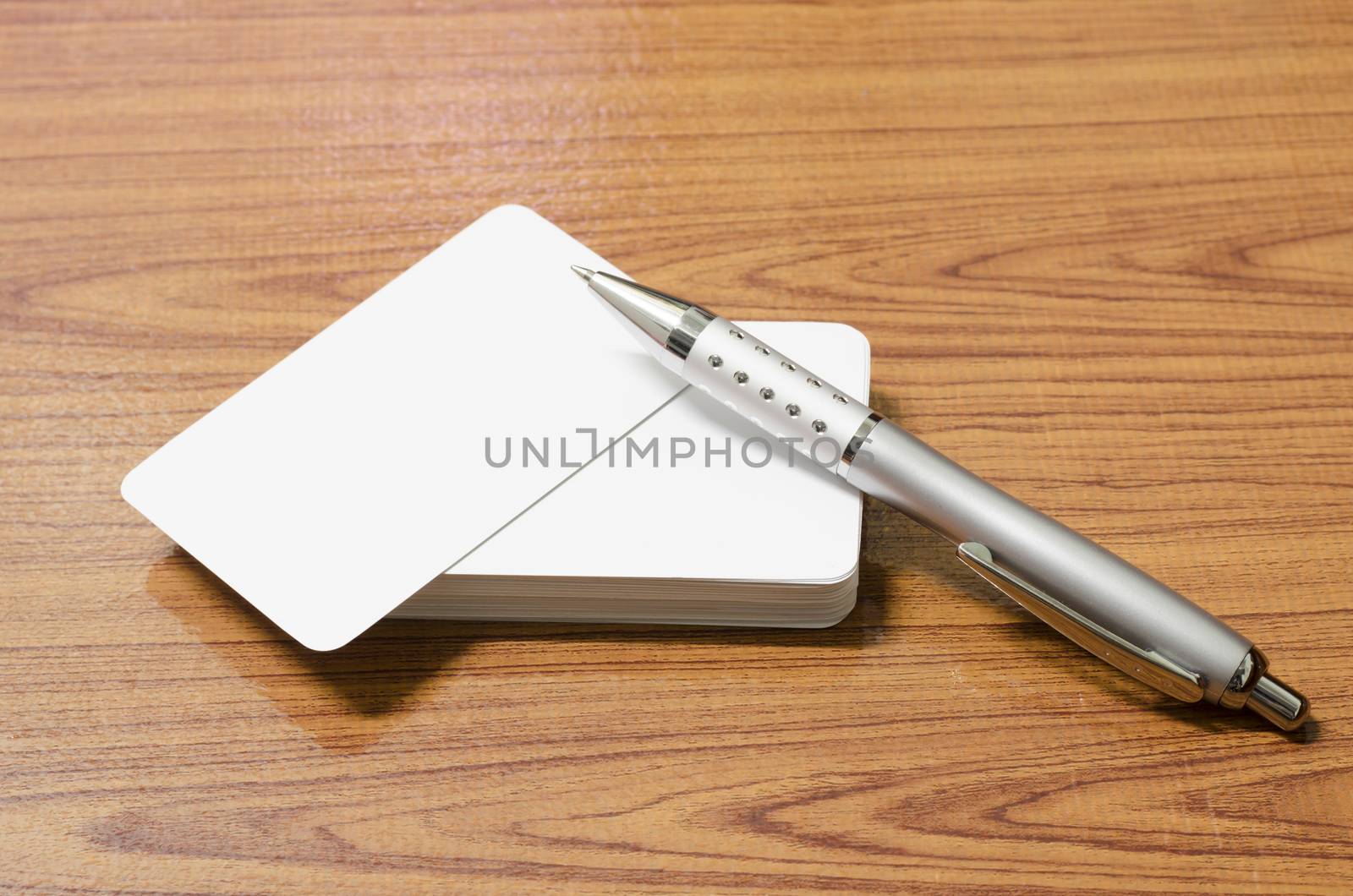 stack of business card with pen on wood background