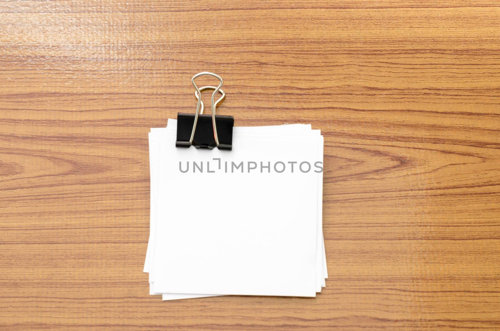 stack of paper with clip on wood background