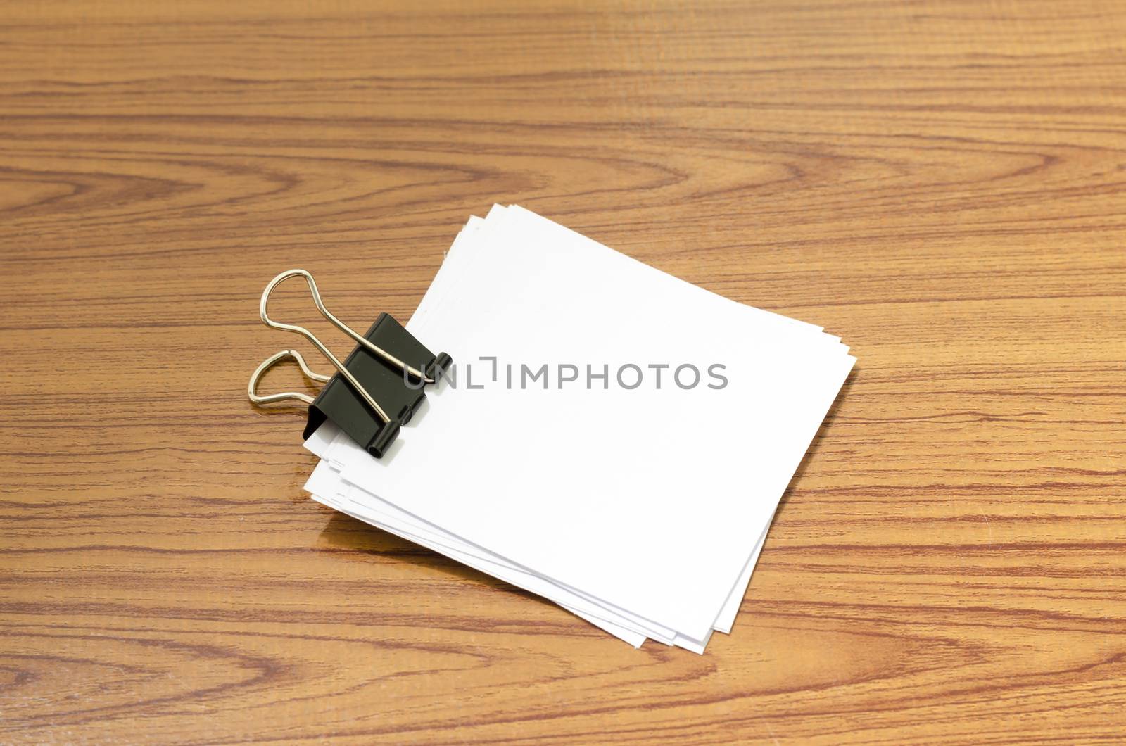 stack of paper with clip on wood background