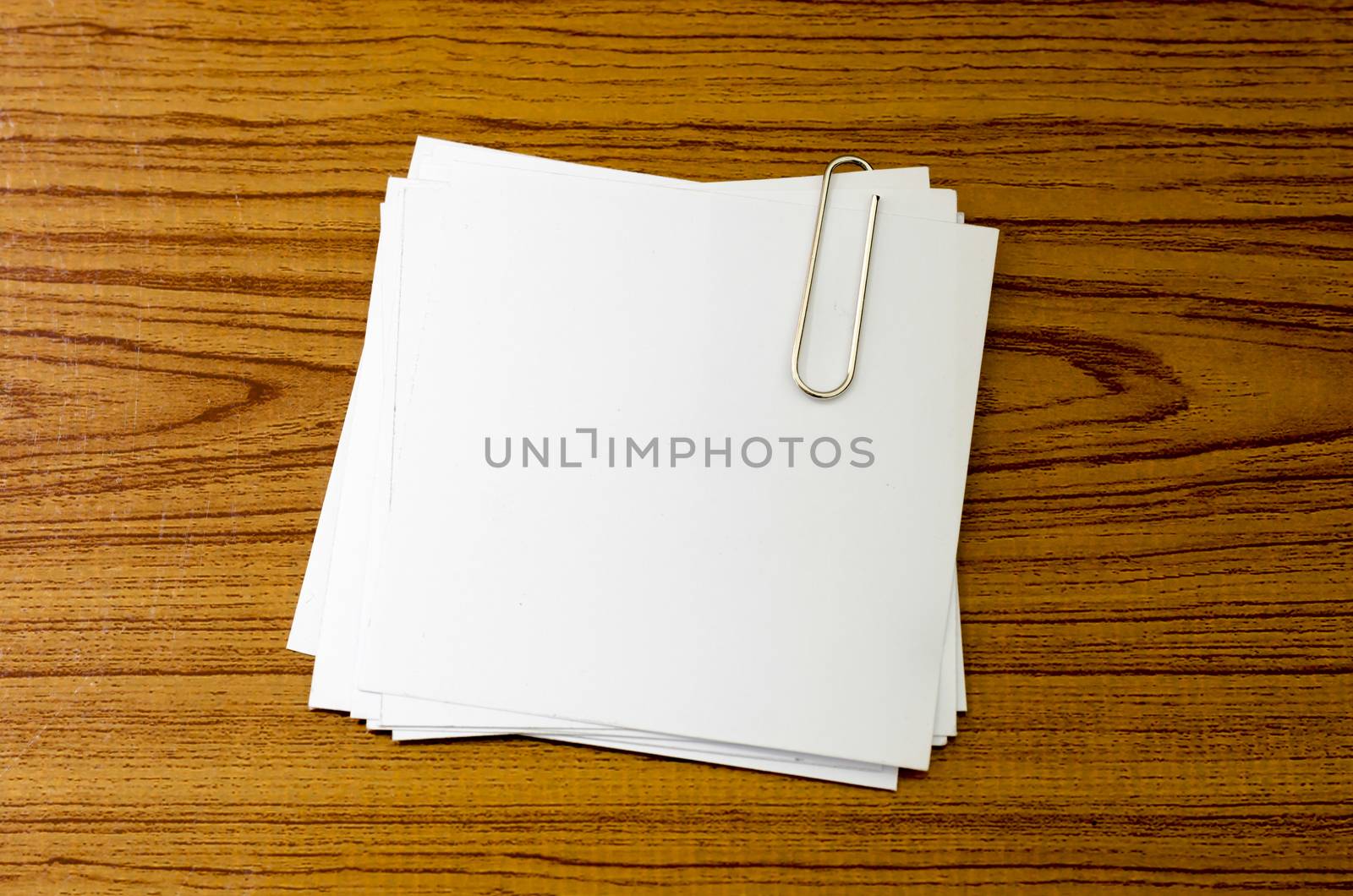 stack of paper with clip on wood background