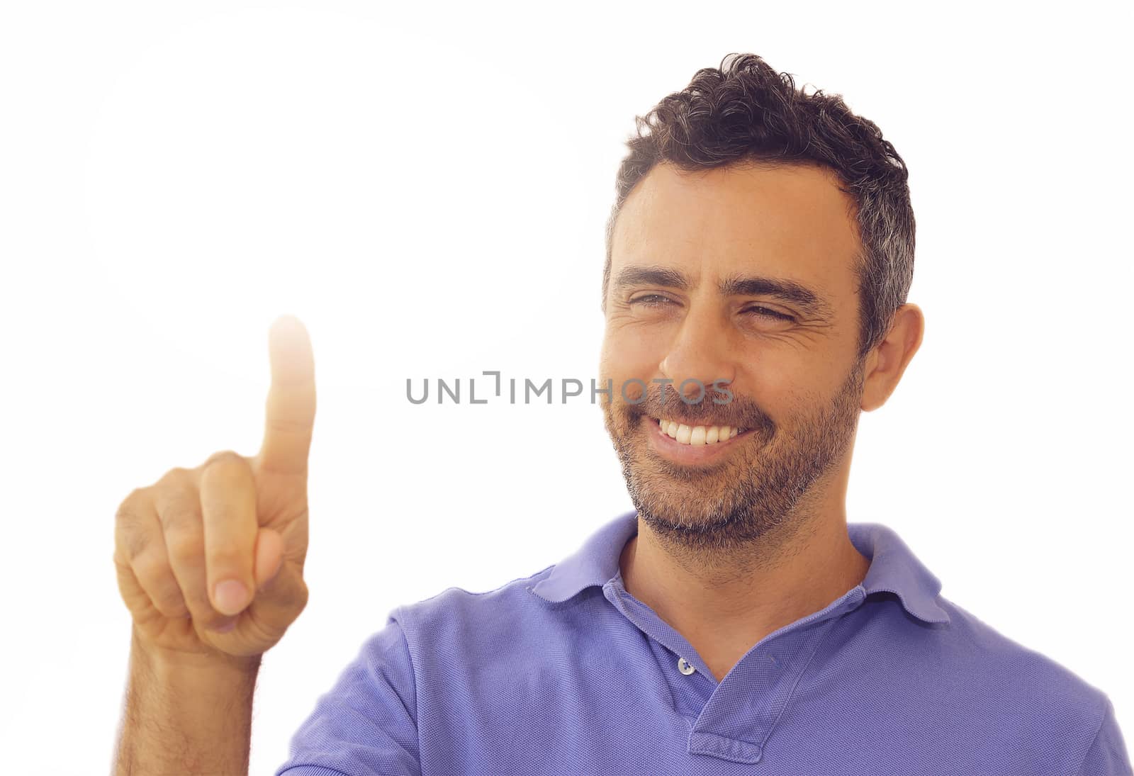 Handsome smiling man activating a touch screen with his finger pointing upwards towards blank copyspace in a communication and advertising concept, on white