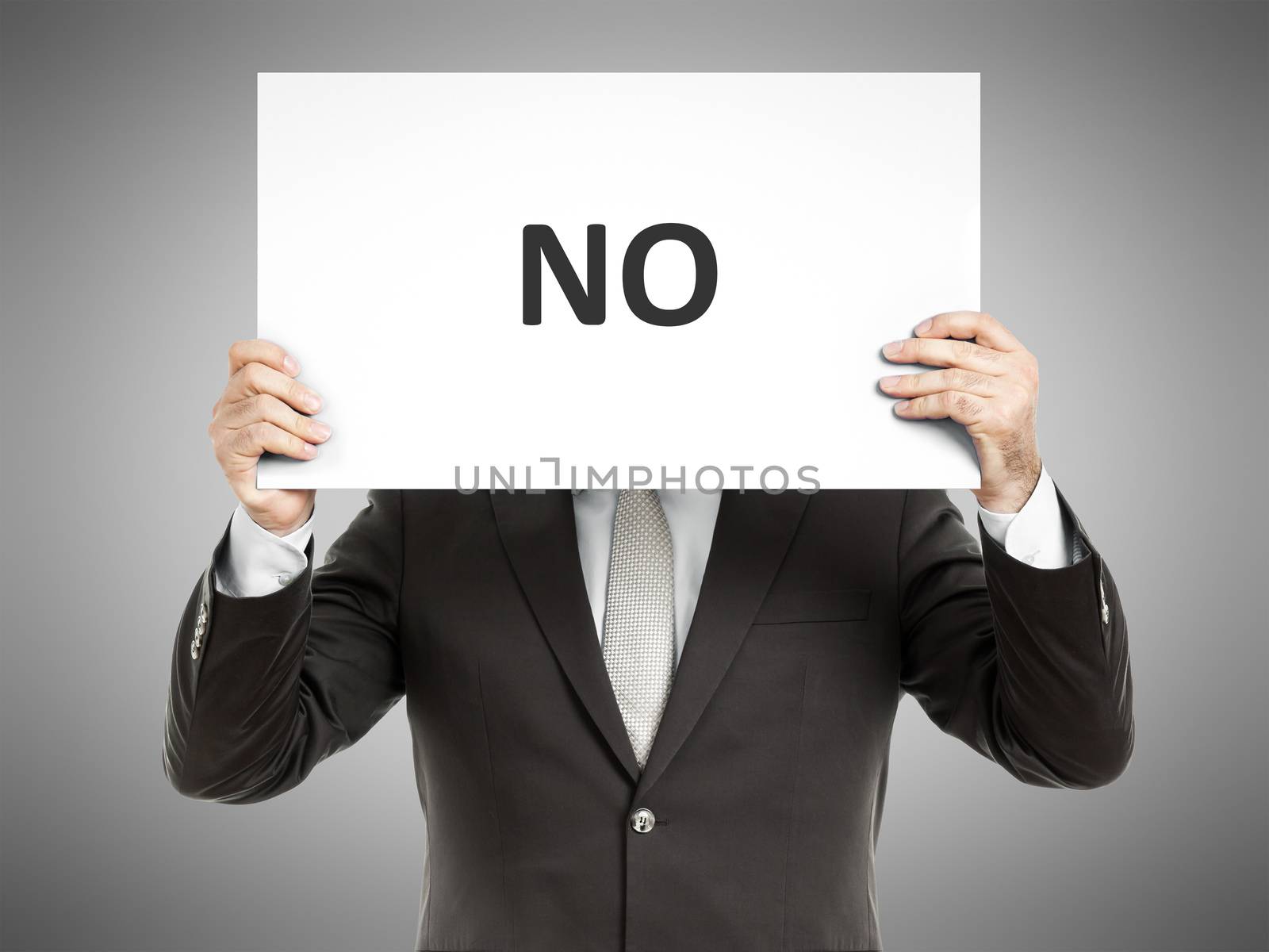 A business man holding a paper in front of his face with the word no