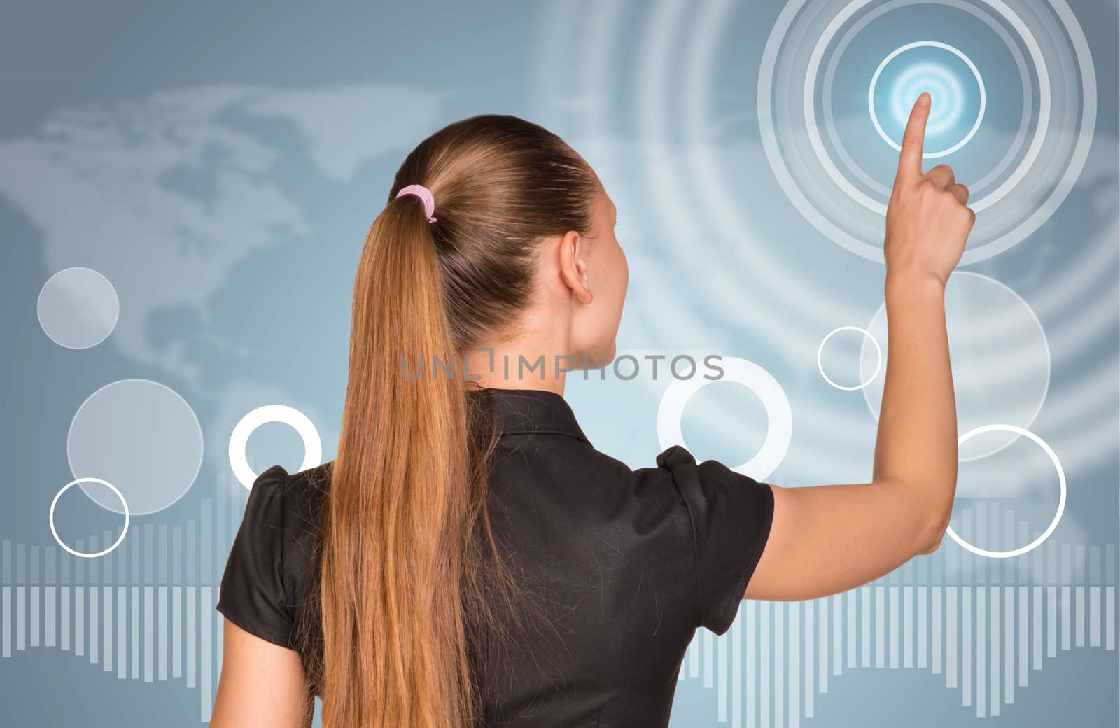 Beautiful businesswoman in dress finger presses virtual button. Rear view by cherezoff