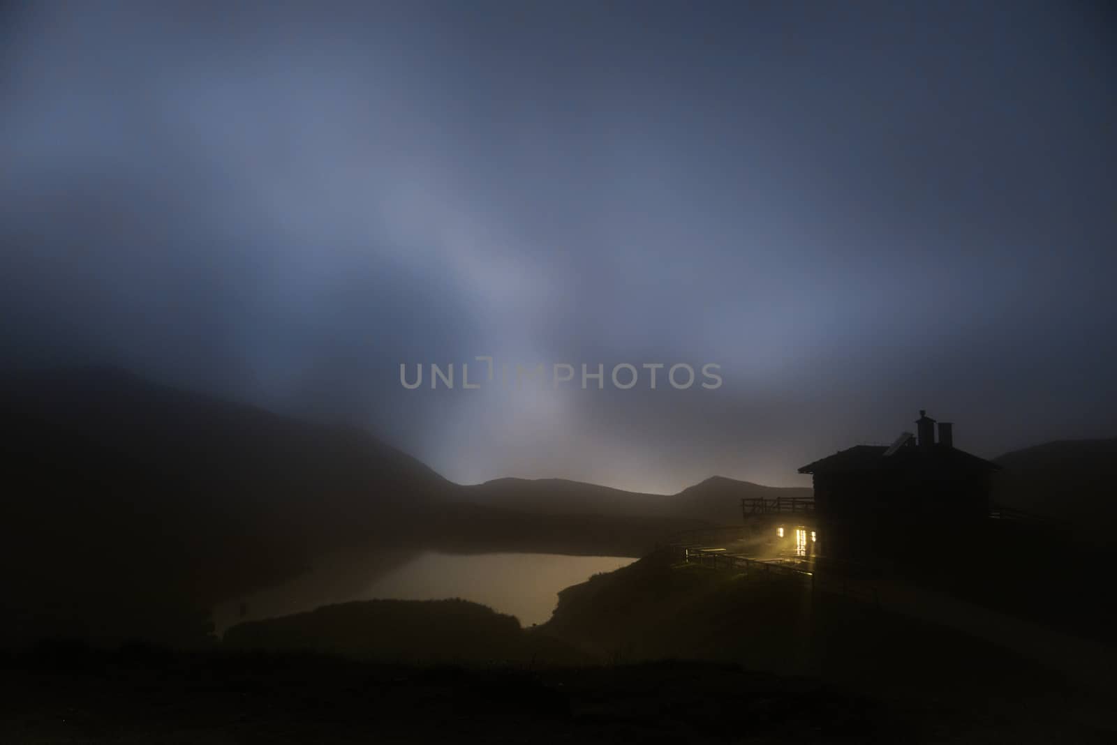 mountain hut and lake in a foggy summer night, Rolle Pass - Trentino, Dolomites