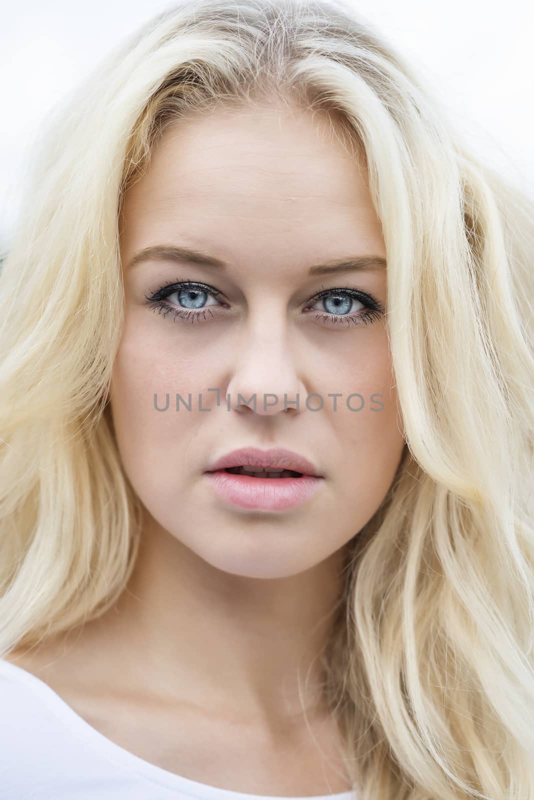 Close outdoor portrait of a young blond woman in summer