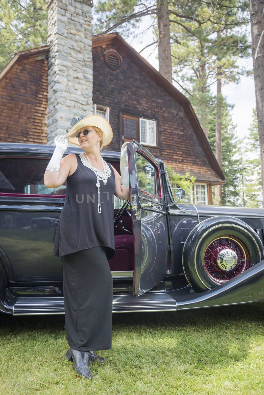 Attractive Young Woman in Twenties Outfit Near Antique Automobile.