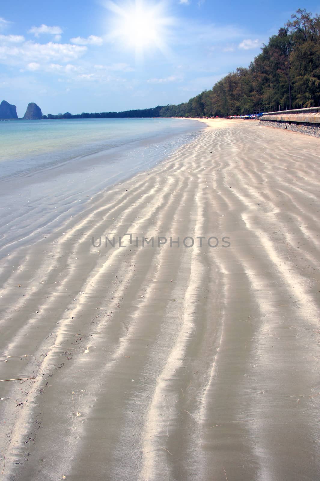 Wave patterns blow sand on the beach. by Noppharat_th