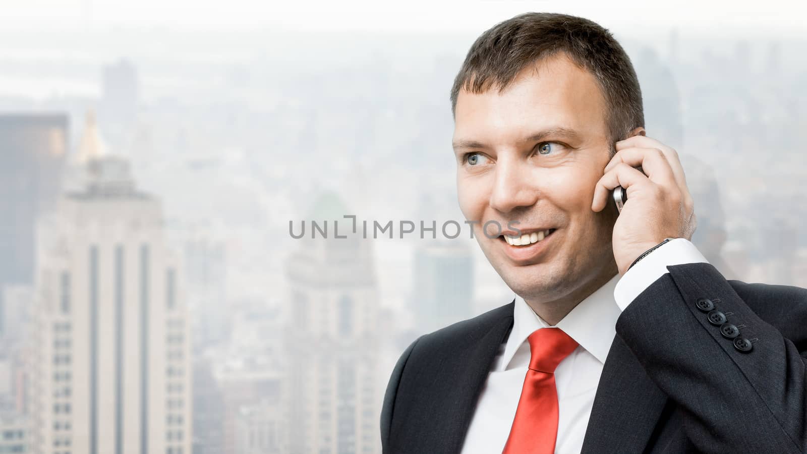 An image of a handsome business man and his mobile phone