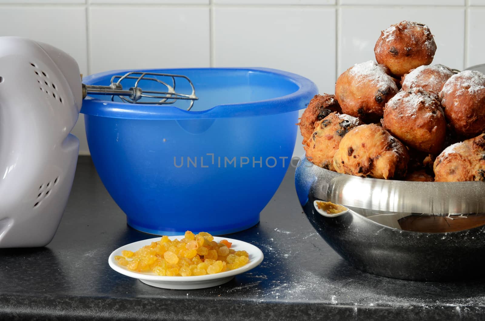 Ingredients like raisins and a hand mixer for baking oliebollen, oil balls or donut balls, a dutch pastry traditionally eaten on New Year’s Eve in the Netherlands. 
