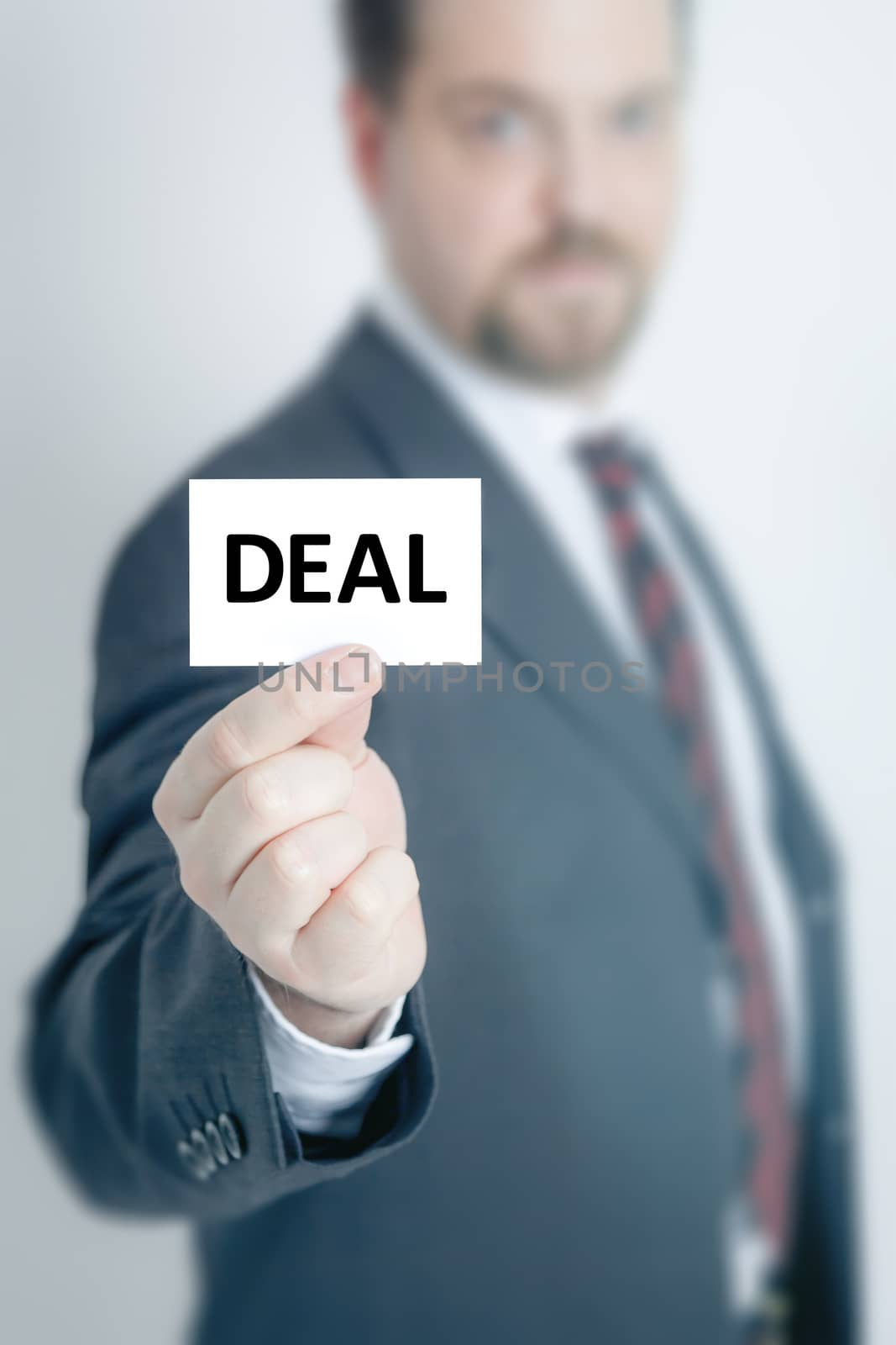 A business man holding a card with the word deal