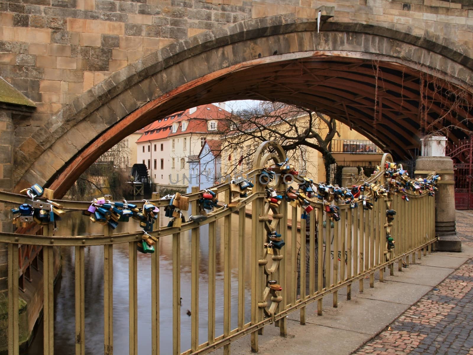 Photo of Charles bridge in Prague, Czech republic with the view onto love locks, old houses, towers and Vltava river.