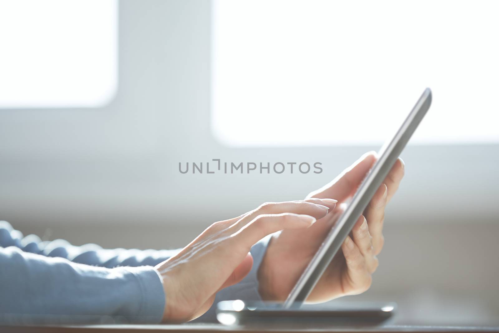 Human hands using tablet computer at home